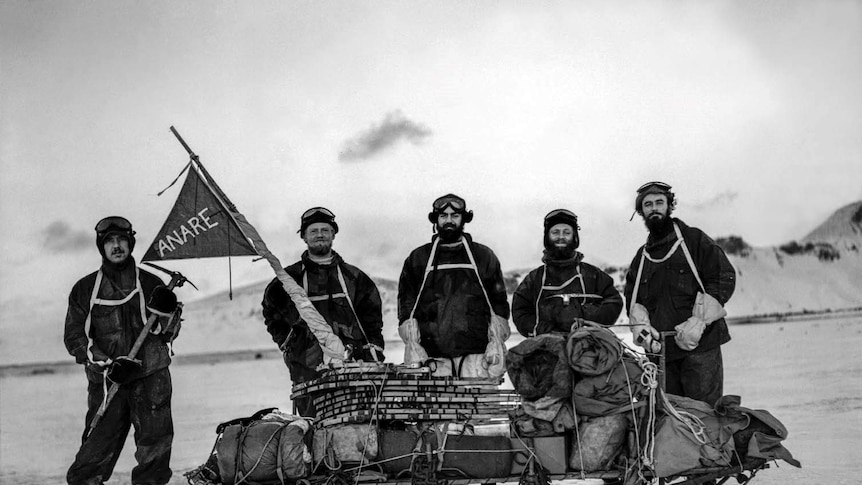 Five men stand next to a sled on Heard Island in 1948.