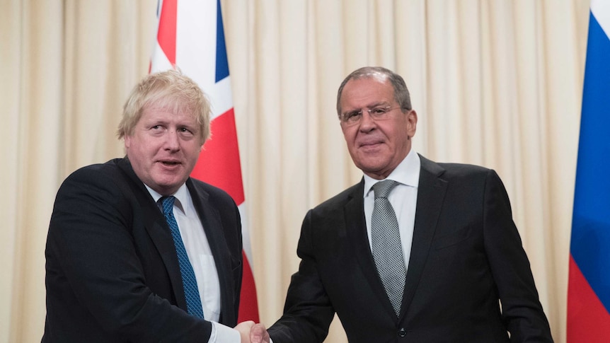 Boris Johnson and Sergei Lavrov shake hands as their photograph is taken.