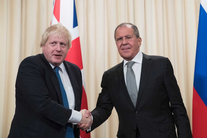 Boris Johnson and Sergei Lavrov shake hands as their photograph is taken.