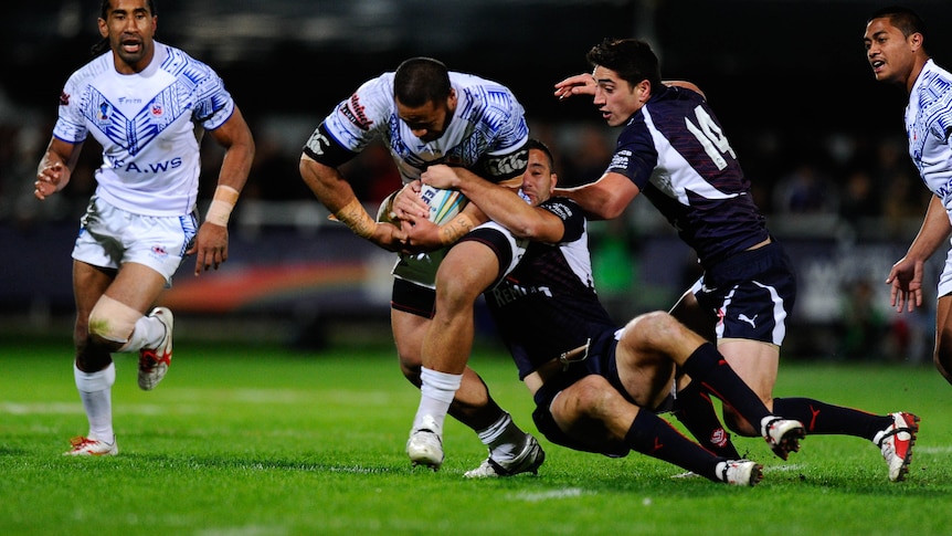 Samoa's Suaia Matagi is held up by the French defence during the Rugby League World Cup match.