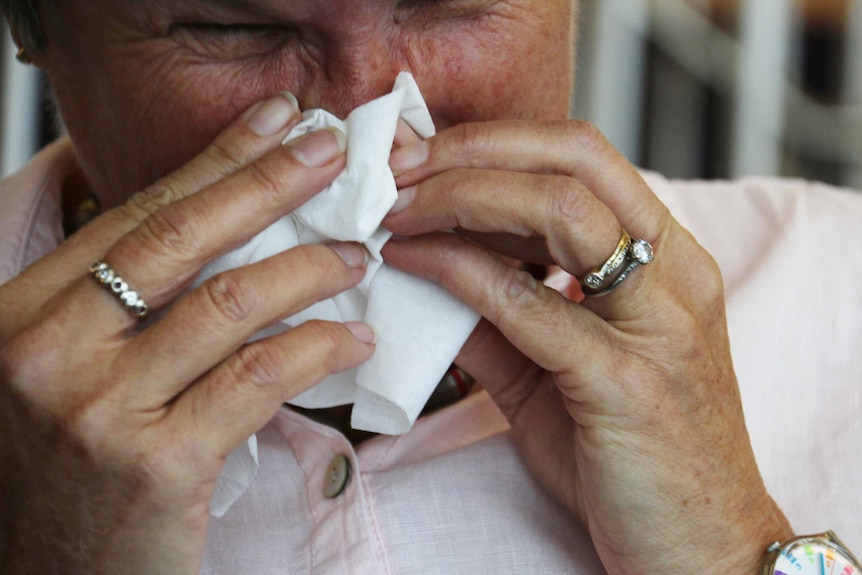 A person blows their nose.