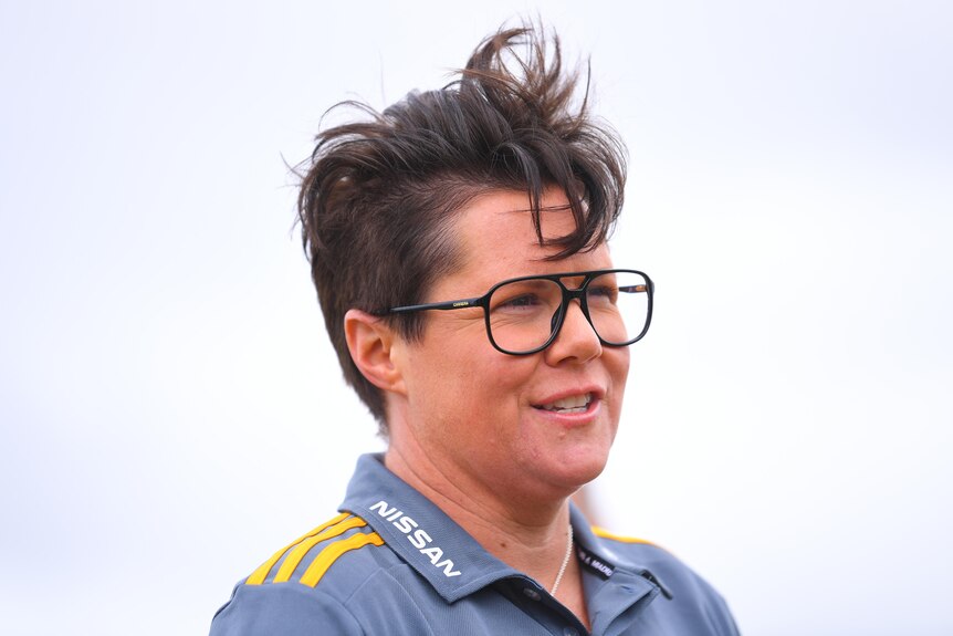 A side view of Bec Goddard wearing large glasses and smiling