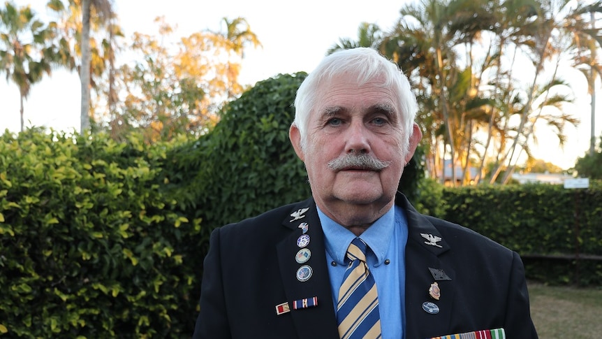 A man in military regalia looks at the camera