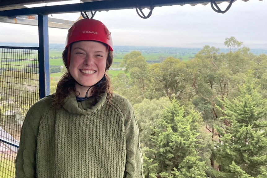 girl wearing red helmet smiling at camera