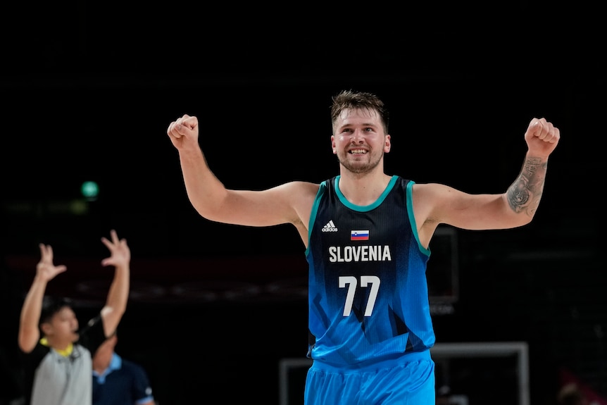 Luka Doncic celebrates by raising his arms during a Tokyo Olympics basketball game against Argentina.