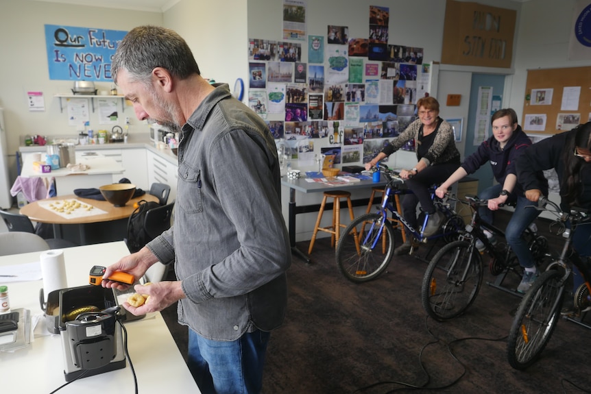Bikes connected to a doughnut fryer by wires are pedalled by students and teachers