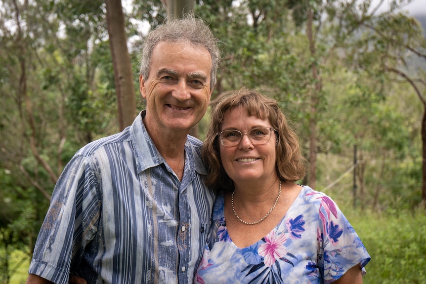 A couple standing next to each other smiling for the camera