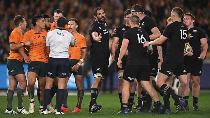 Wallabies and All Blacks players on the field with referee Mathieu Raynal.