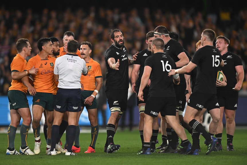 Wallabies and All Blacks players on the field with referee Mathieu Raynal.