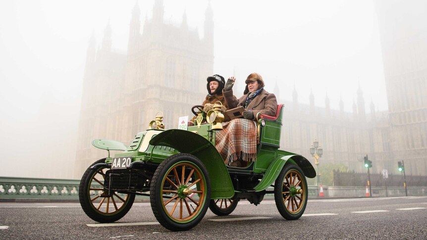 A vintage car passes the Houses of Parliament in London shortly after beginning the Veteran Car Run.