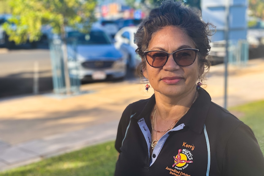 headshot of indigenous woman wearing sunglasses with blurred background