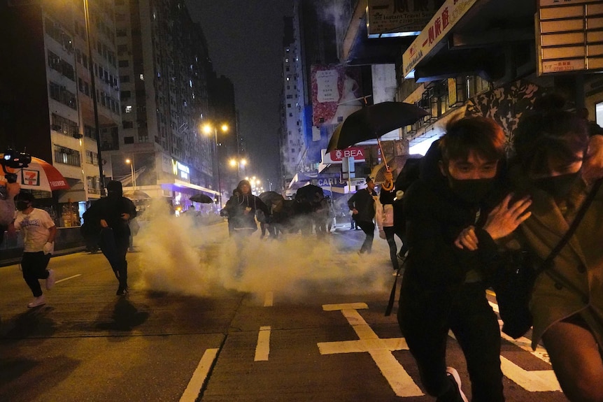 Protesters react as police fire tear gas during a demonstration in Hong Kong.