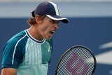 Alex de Minaur shouts and clutches his tennis racquet at the US Open.