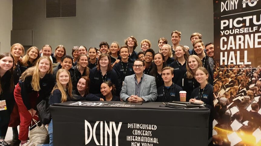 The choir of teenaged students pose with composer Paul Mealor.