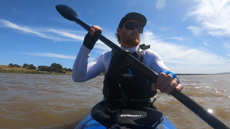 A man kayaking in a river.