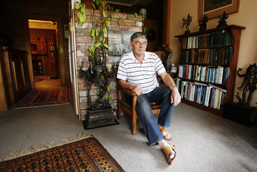 Older man sitting in an armchair in his loungeroom 