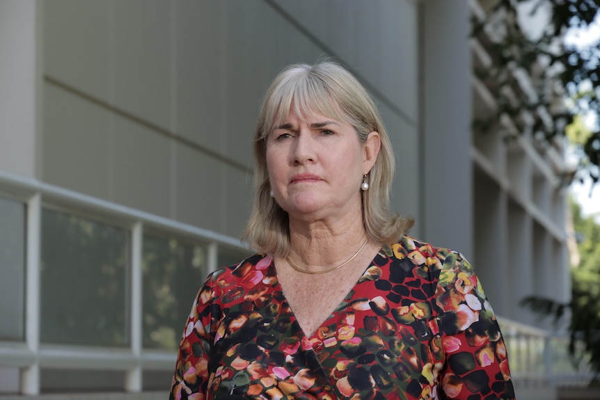NT Treasurer Eva Lawler standing outside NT Parliament House, looking serious.