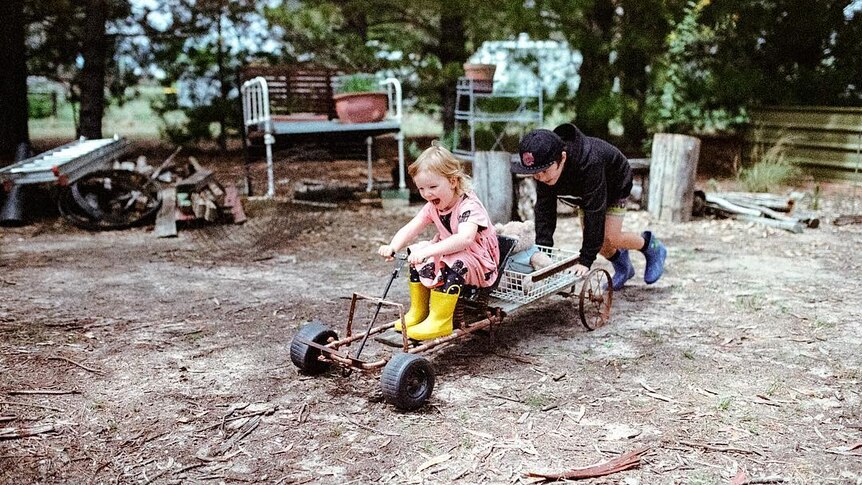 Two children play with a home made billycart.