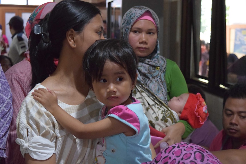 Woman holds child at medical clinic