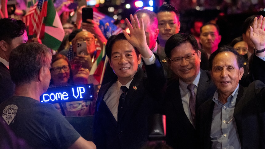 A man in suit surrounded by crowds. 