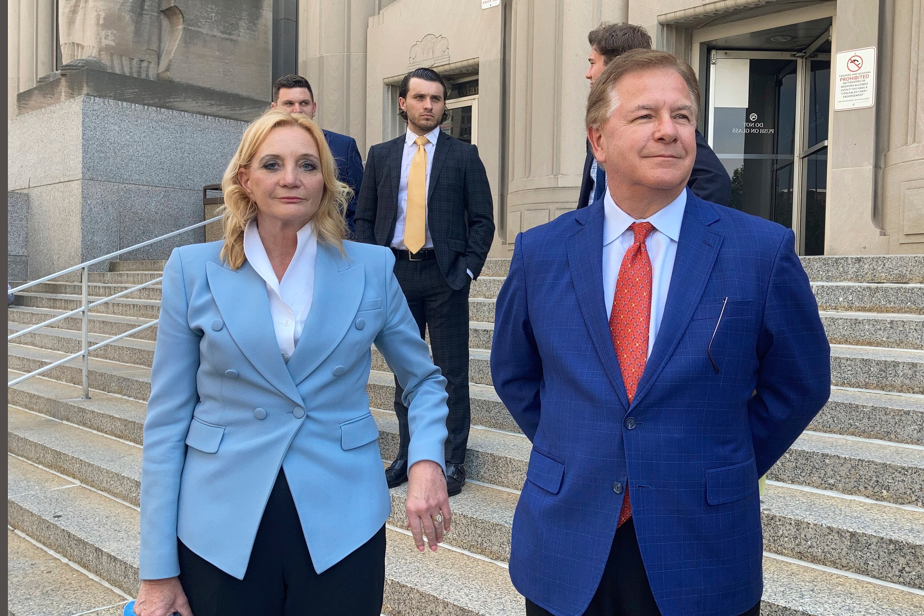 Patricia McCloskey looks at the camera with Mark McCloskey next to her on the steps of the court.