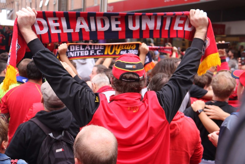 Adelaide United fan holds up scarf