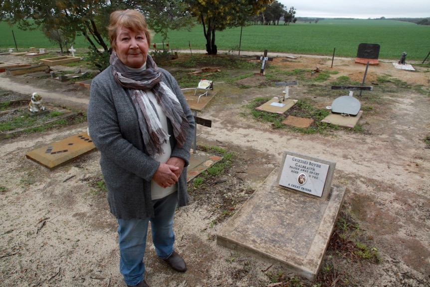 June Galbraith stands beside the grave of her dog Grizzles