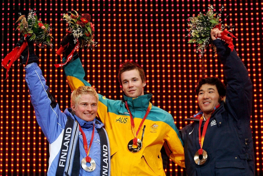 Dale Begg-Smith poses with his gold medal after winning the men's freestyle skiing moguls event at the 2006 Olympics in Turin.
