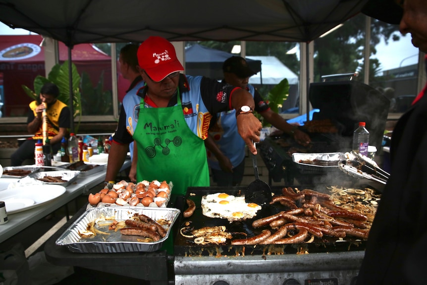 A man cooks at a barbecue