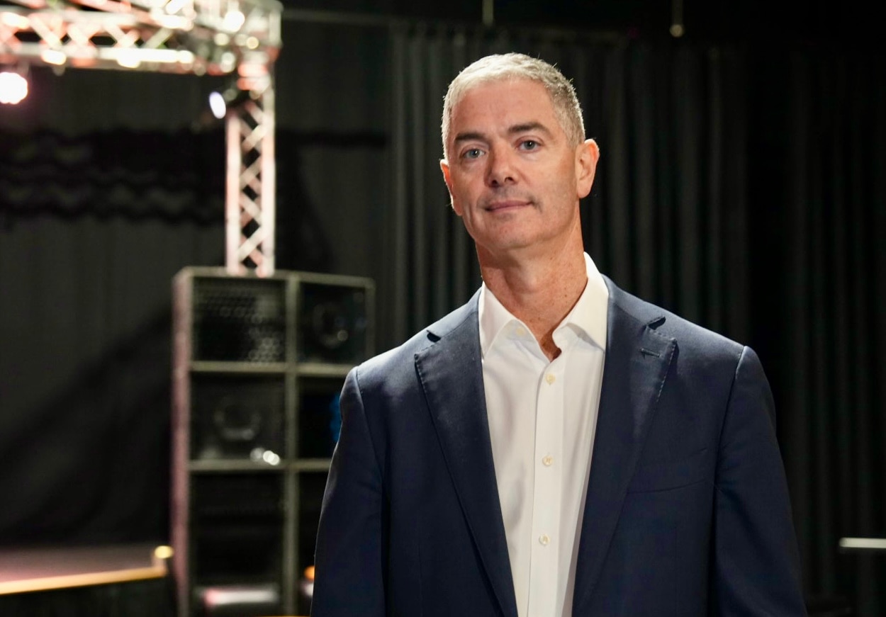 John Graham viste una chaqueta y posa para una fotografía en el teatro.