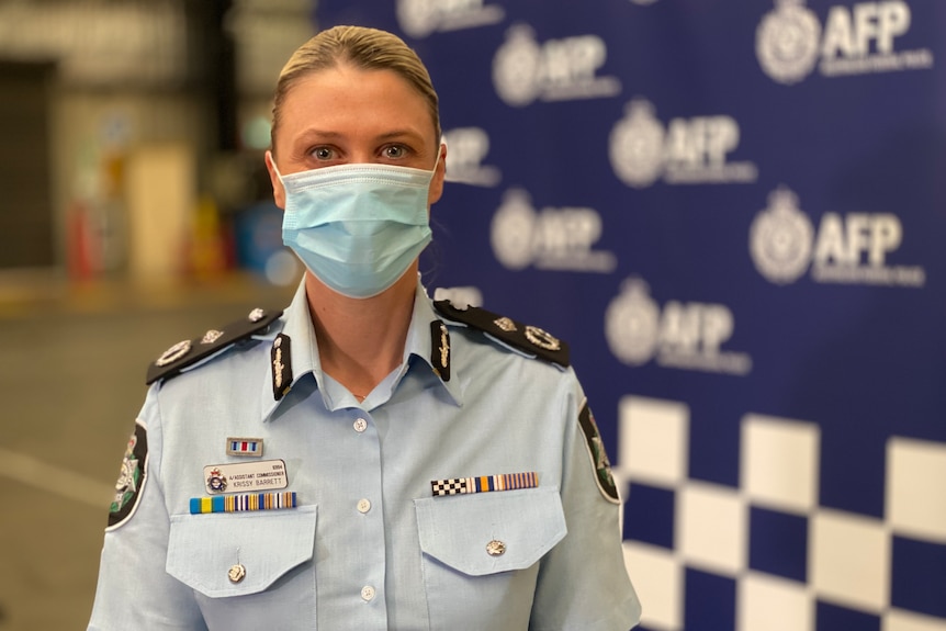 A woman in an Australian Federal Police uniform wearing a mask.