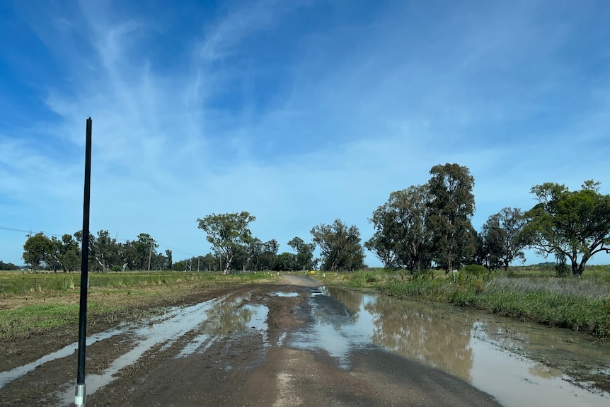 A damaged country road with water across it.