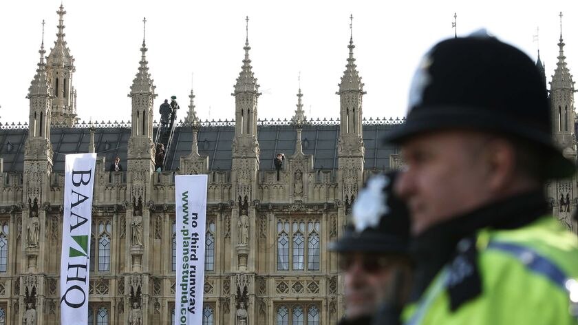 Protestors cupy the roof of the Houses of Parliament in London