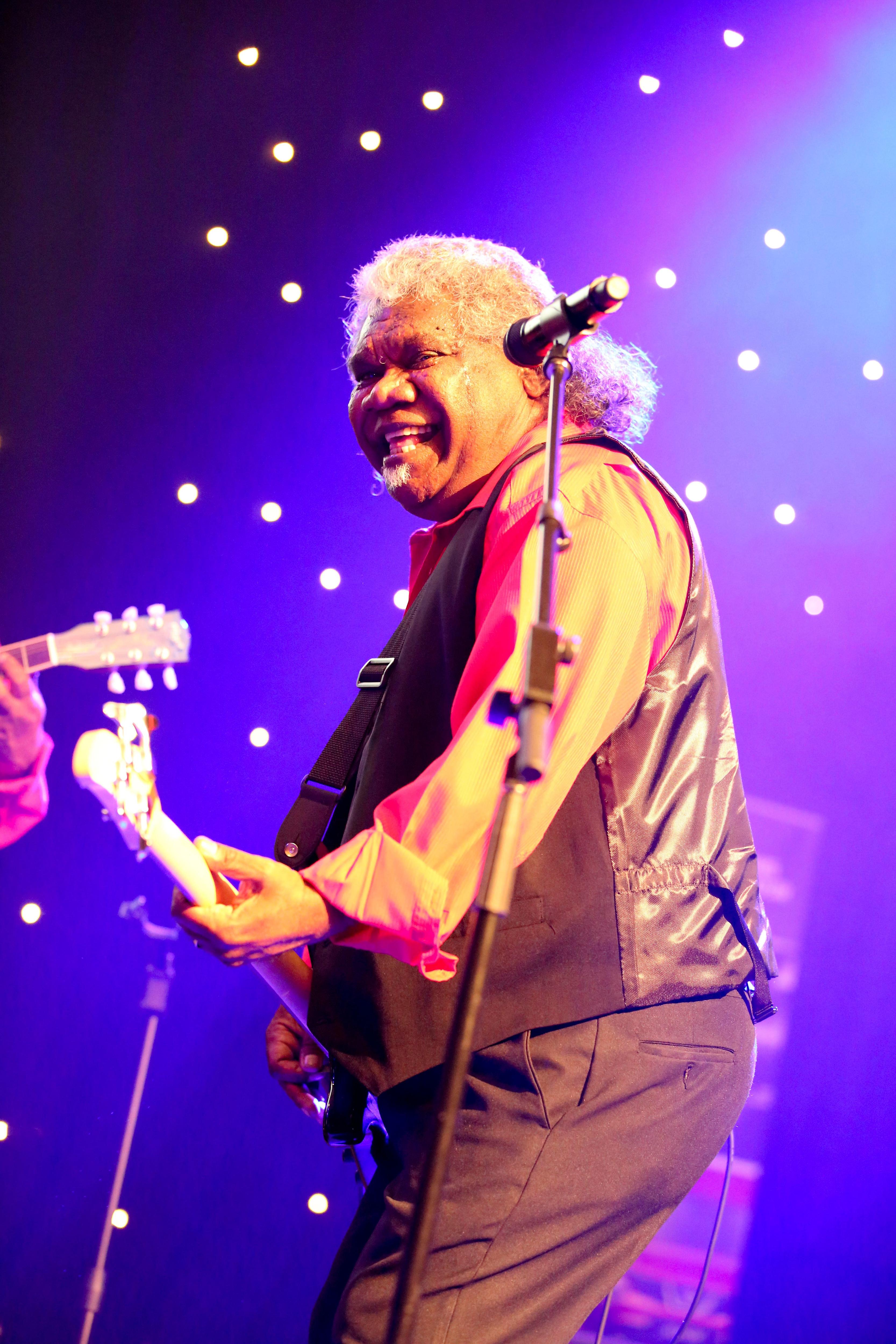 An image of Uncle Robert Bimbo Duncan playing guitar smiling 
