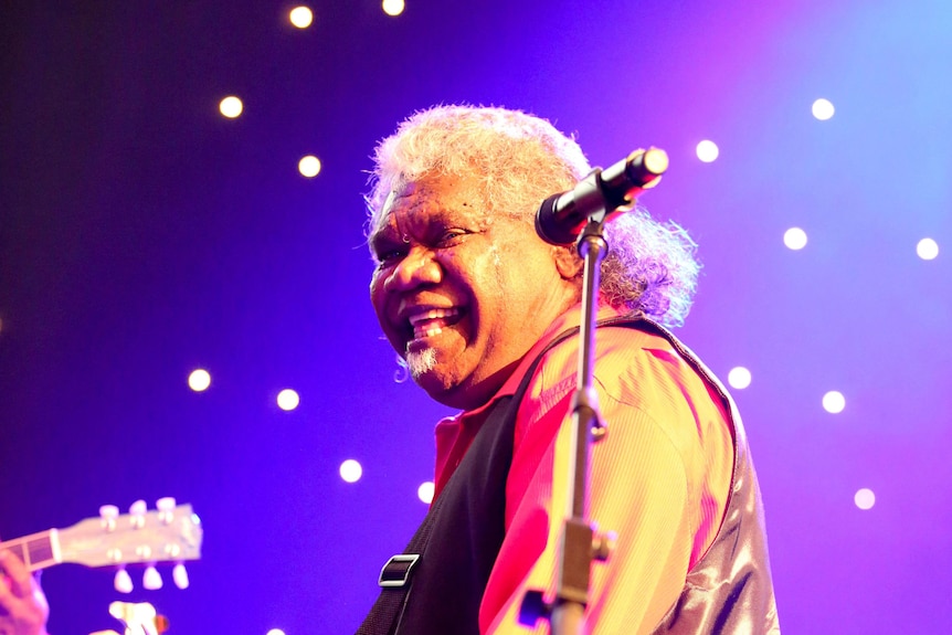 An image of Uncle Robert Bimbo Duncan playing guitar smiling 