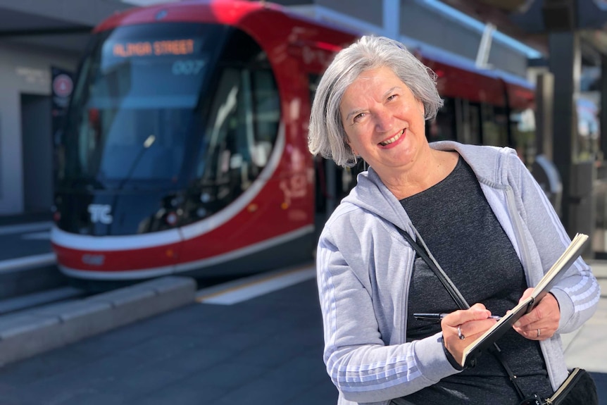 Bobby Graham the tram sketcher standing at the light rail platform in Gungahlin