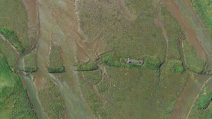Aerial view of sunken vessels in a river bed.