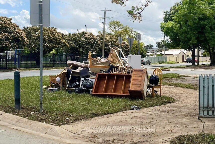 A pile of furniture including chairs and bookshelves lie in a stack on a kerb in Mooroopna. 