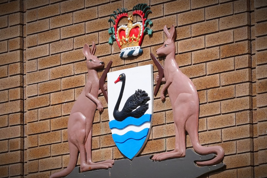 A state coat of arms on the brick wall of a court house