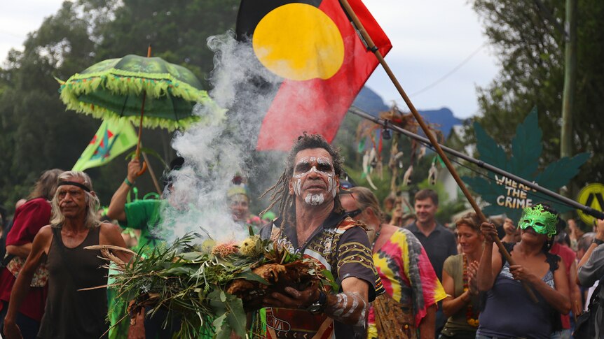 Bundjalung man holds burning native flora at Mardi Grass parade