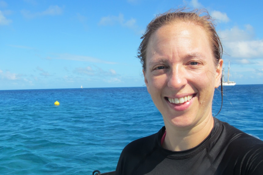 Lauren Heinen selfie from on boat. Wide and blue ocean behind her with a yellow buoy floating behind