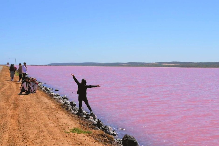 Chinese tourist poses for photo at the Pink Lake in Port Gregory