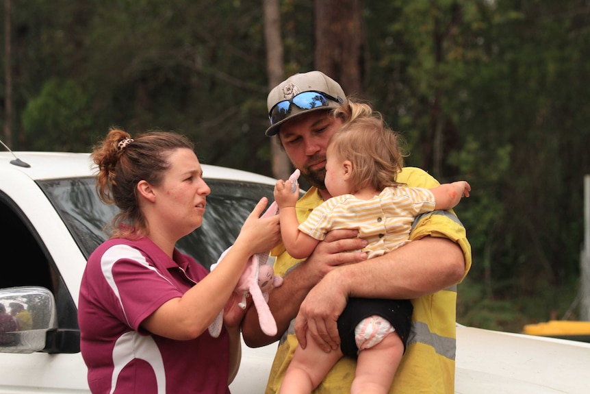 Emily Carter talks with her daughter Millie, who is being held by her partner, Tim Ward