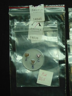 Three pink diamonds labelled A, B and C in zip-seal bags with an Argyle label.