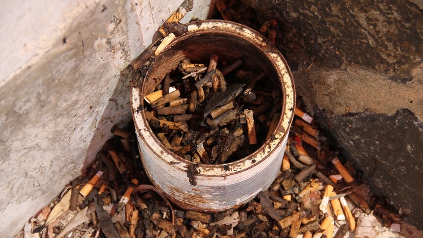 Cigarette butts around an old can