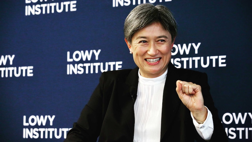 Penny Wong smiles with her left fist in the air.