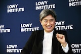 Penny Wong smiles with her left fist in the air.