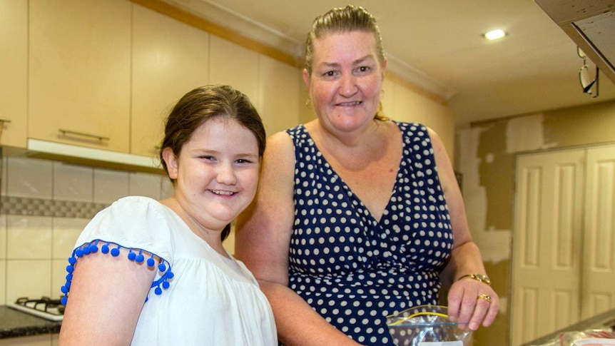 Louise Holland and her daughter Victoria, 13, prepare food they’ve received from a food relief organisation