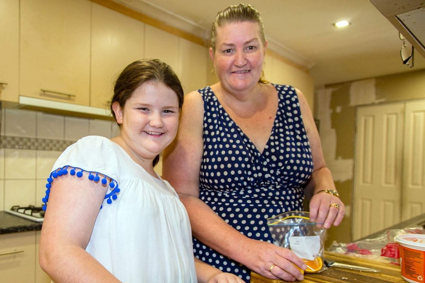 Louise Holland and her daughter Victoria, 13, prepare food they’ve received from a food relief organisation