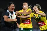New Zealand's Amber Hall runs away from three Jillaroos defenders at the Rugby League World Cup.